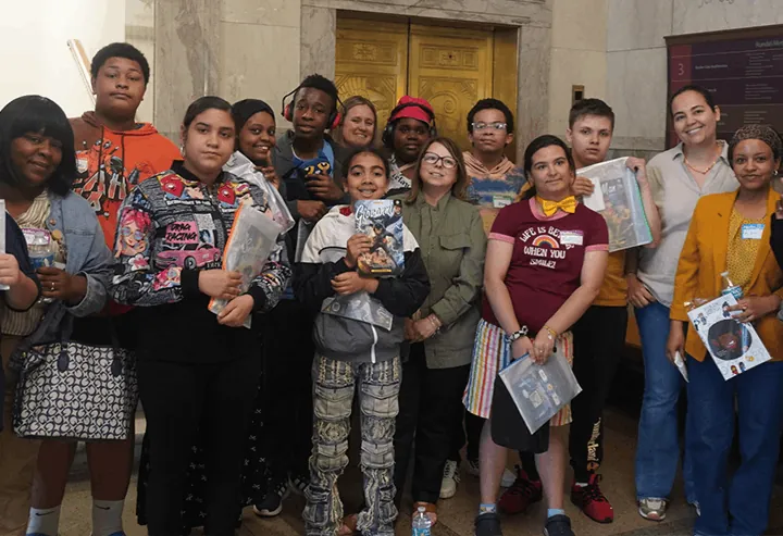 A group of young people outdoors holding up their printed comic books